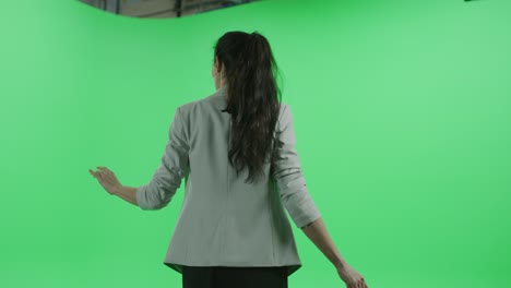 green screen chroma key studio: beautiful mature woman looks around in wonder. 360 degree medium tracking arc shot