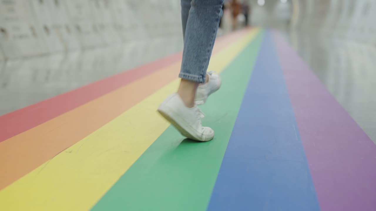 gen z gay alegría diversión caminar vista de bajo ángulo con zapatillas blancas y vaqueros.