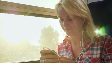 Young-Woman-On-A-Train-Using-A-Mobile-Phone