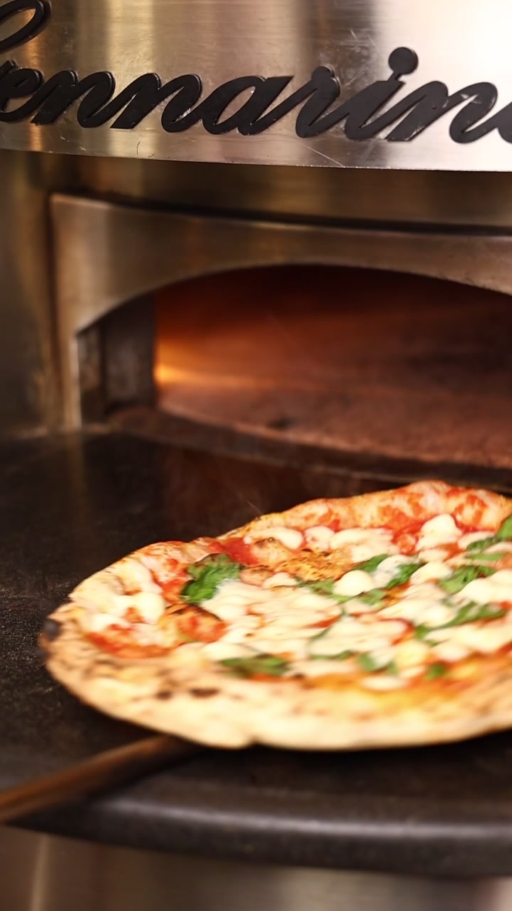 Pizza Margherita appena sfornata rimossa dal forno a legna