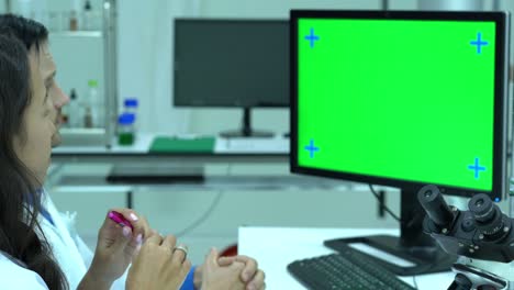 científico masculino hablando de trabajar en un laboratorio moderno o centro médico. monitor de fondo pantalla verde. concepto de ciencia, desarrollo de pruebas y industria de laboratorio.