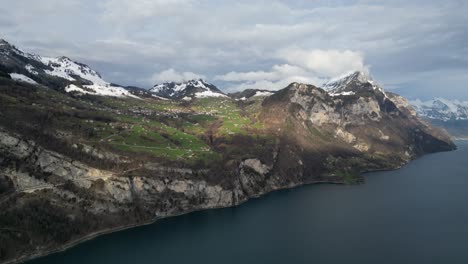 La-Luz-Del-Sol-Brilla-En-Las-Laderas-Cubiertas-De-Hierba-Sobre-El-Lago-Walen-En-Casas-De-Campo-En-La-Base-De-Montañas-Nevadas