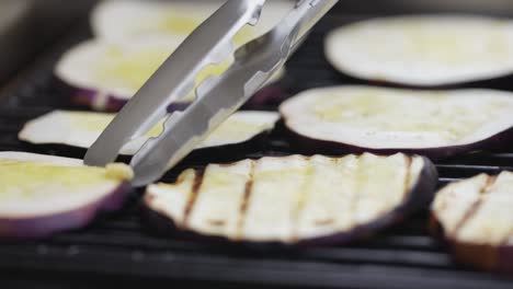 turning aubergines on outside grill