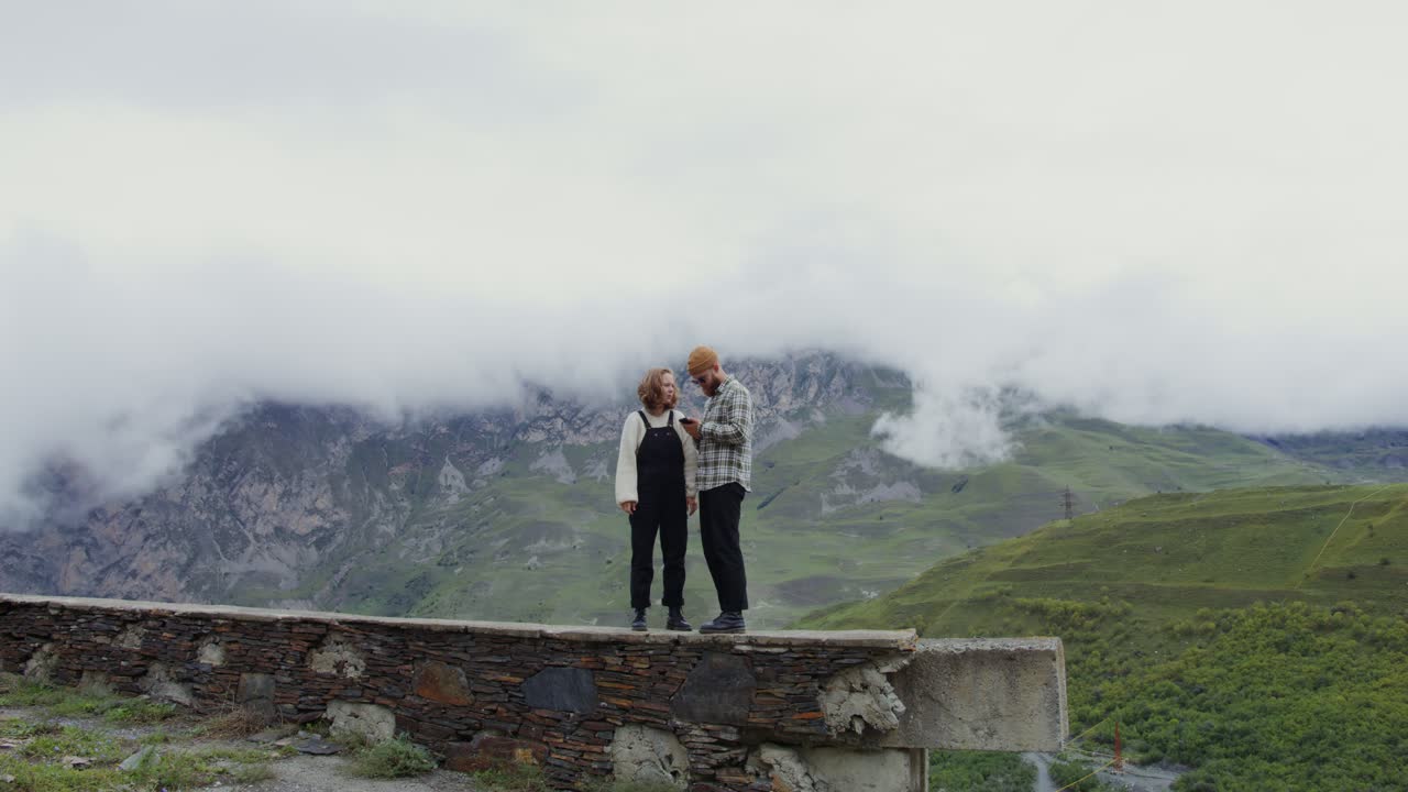 пара фотографируется на вершине горы