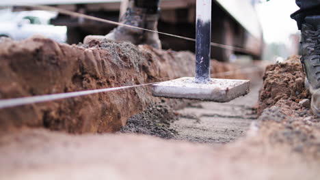 trabajador de la construcción manualmente ram arena en un canal con rammer hummer