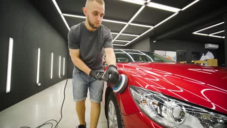 headlight polishing, processing of car lights. a car service worker polishes the headlight of a passenger car. professional polishing.