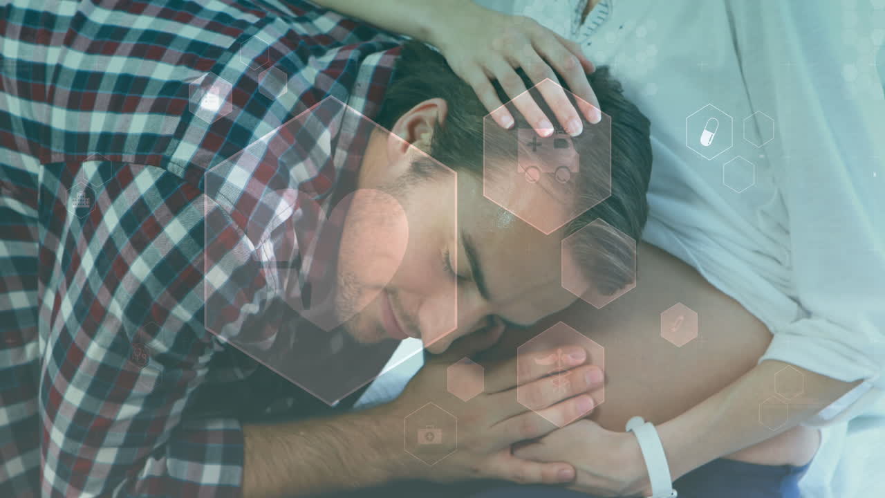 Animation of medical icons over happy caucasian man embracing pregnant wife