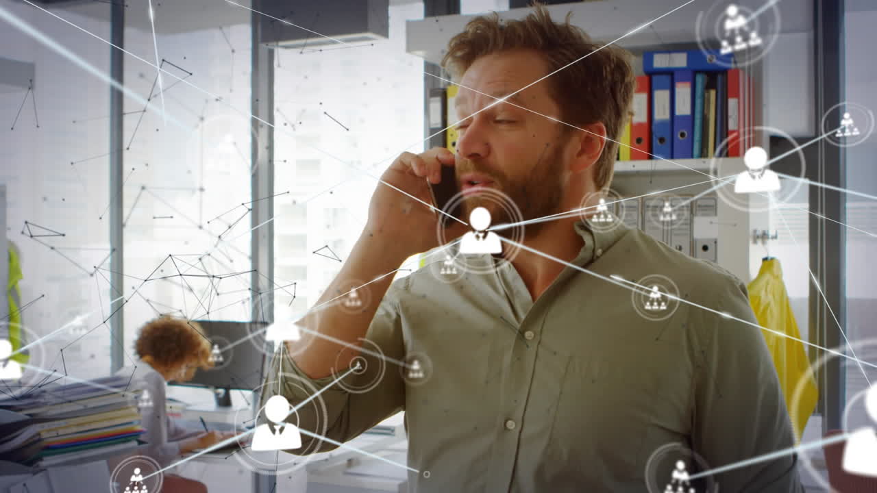 animación de la red de iconos de perfil contra el hombre caucásico hablando en el teléfono inteligente en la oficina.