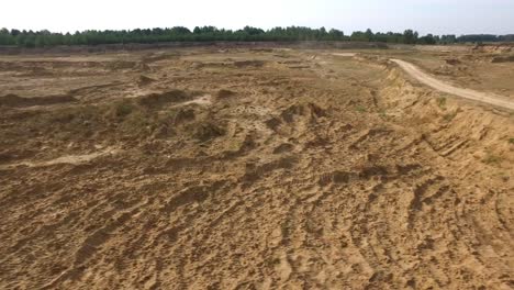 vista aérea de un camión dumper conduciendo en un camino de tierra en una cantera de arena