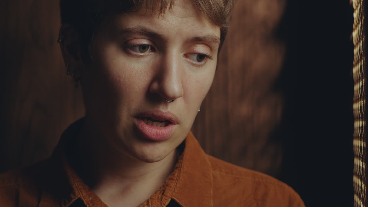 Young Woman Telling about Sins to Priest in Confession Booth
