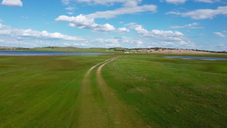 gran prado verde con un lago en el fondo