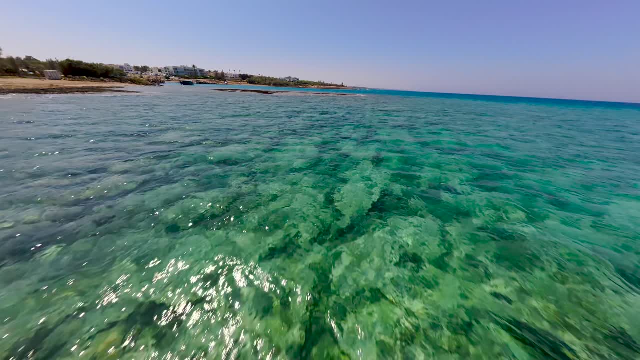 Calm waters showcase a rocky seabed in a tropical location under bright sunlight. This beautiful, serene view highlights the stunning natural beauty of the ocean