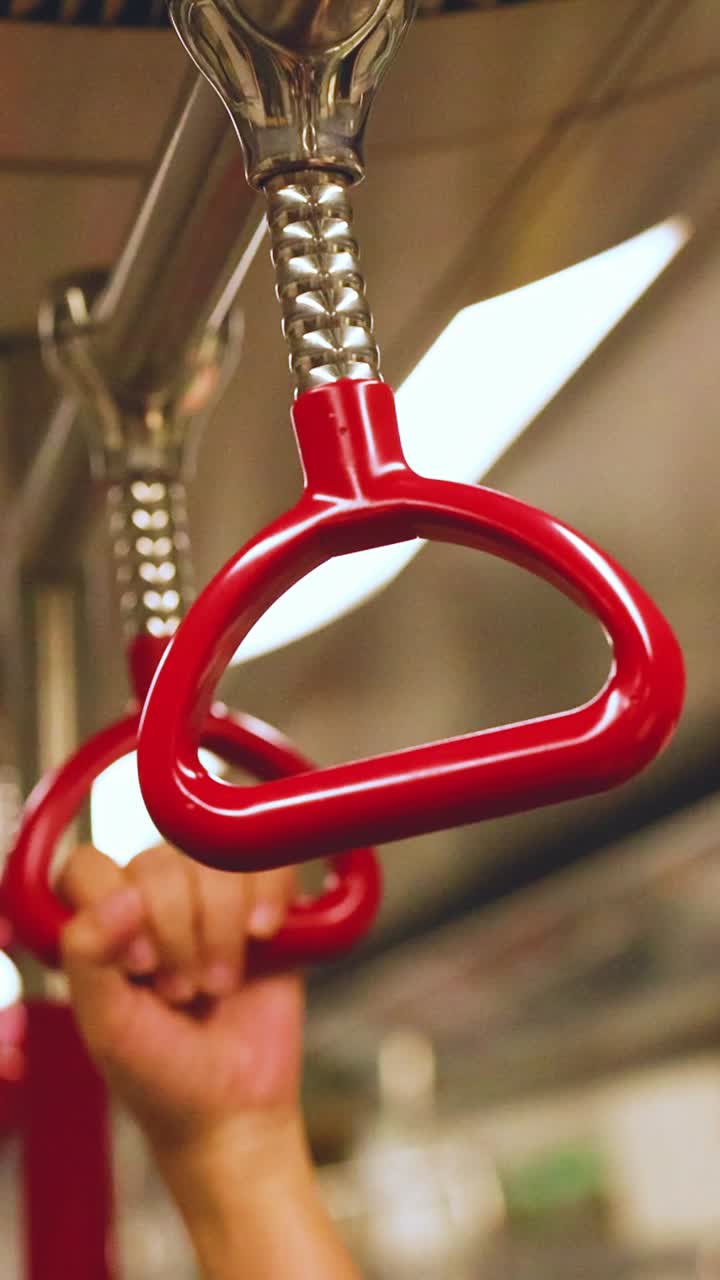 manos agarrando manijas en un tren en movimiento