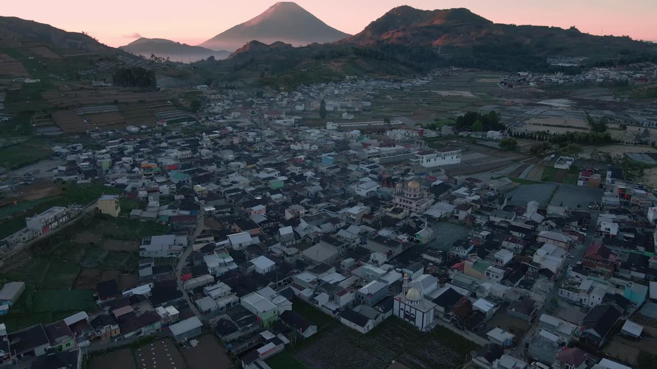 해가 뜨는 시간 에 산맥 의 아름다운 전망 과 함께 디엔 고원 에 있는 마을 을 날아다니며 - 인도네시아 시골 의 4k 드론 촬영