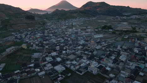 Fliegen-Sie-über-Das-Dorf-Auf-Dem-Dieng-Plateau-Mit-Schöner-Aussicht-Auf-Die-Bergkette-Bei-Sonnenaufgang---4K-Drohnenaufnahme-Der-Indonesischen-Landschaft