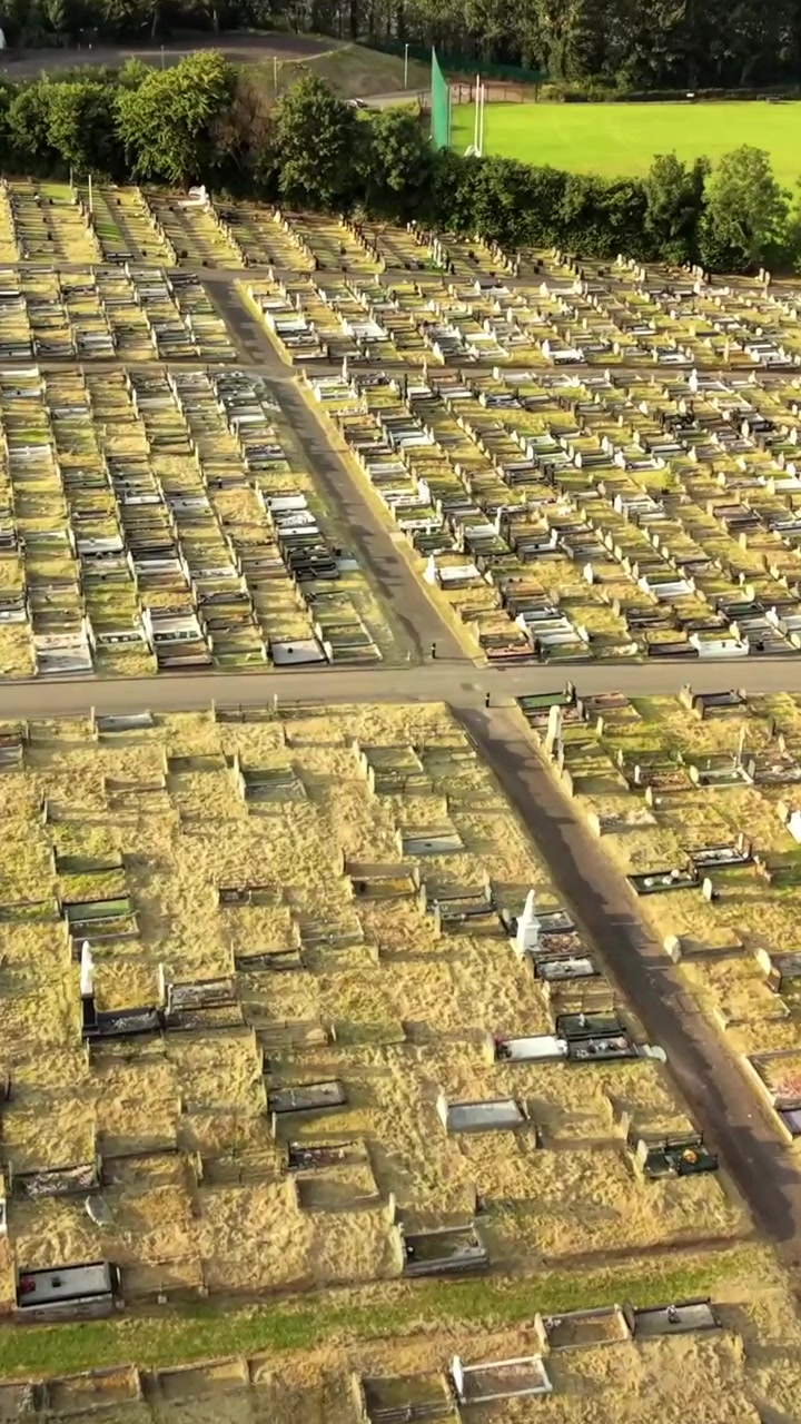 Video aereo discendente del Cimitero di Milltown a West Belfast, Irlanda del Nord, in una sera luminosa. Prodotto a 60 FPS, rapporto sociale 1080x1920 e con colore Rec709.