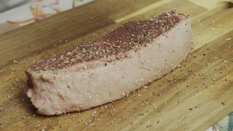 agregando especias al bistec de carne en la tabla de cortar