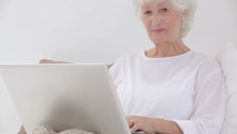 mujer vieja usando una computadora portátil