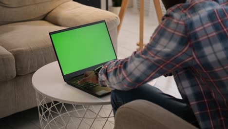hombre usando una computadora portátil con pantalla clave de croma verde