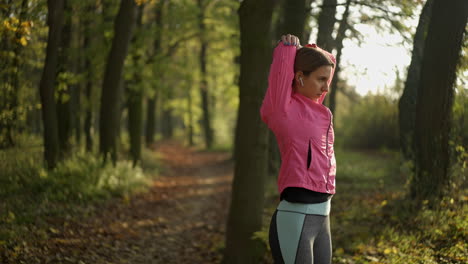 woman stretching before running in an autumn park