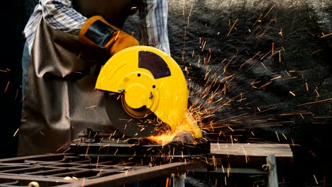 industrial worker using electric grinder machine.