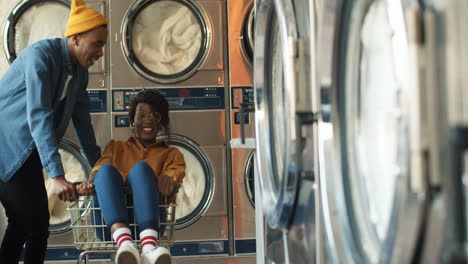 young joyful couple having fun in laundry service room