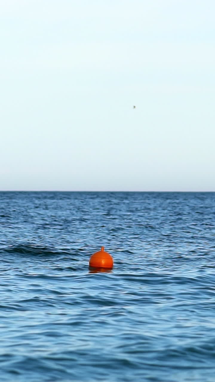 Navigational buoy in sea. Orange buoy floating in sea water