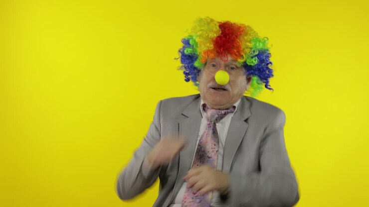 Elderly clown businessman entrepreneur dancing, celebrate, making silly faces