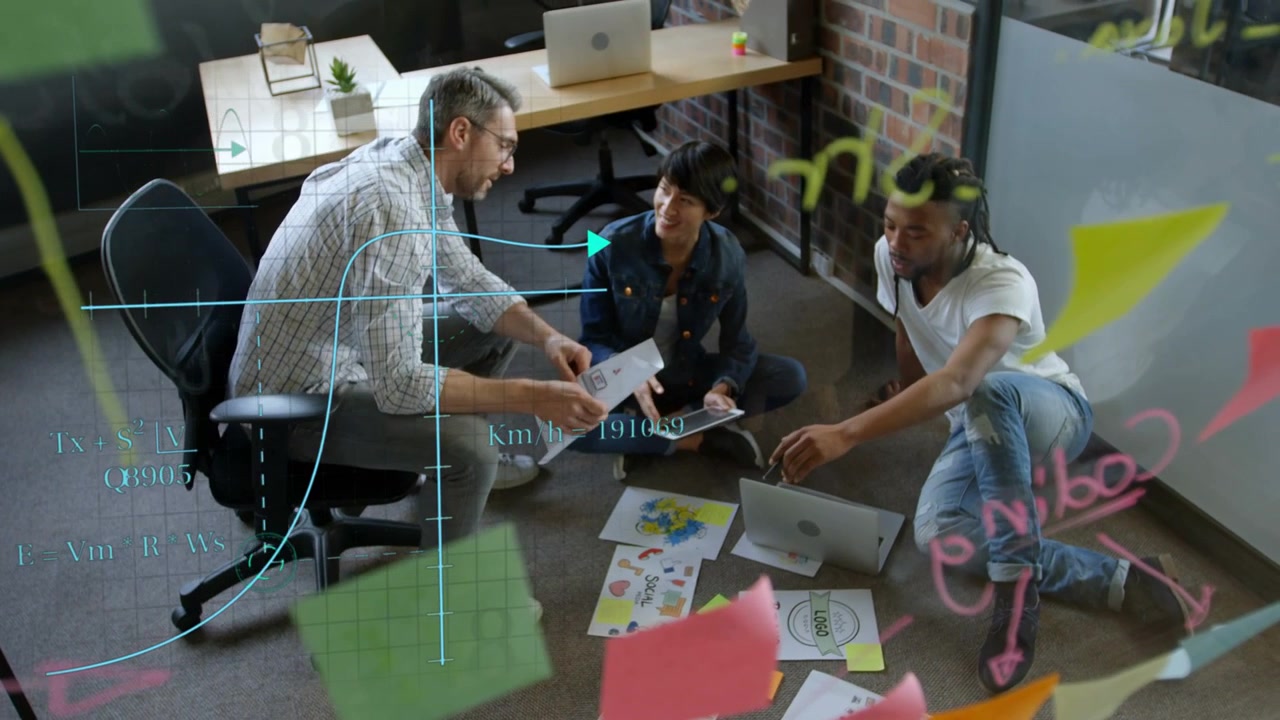 Man leaning forward presenting printout, design team rearranging mockups, finalizing branding