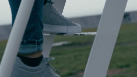 close-up-woman-climbing-ladder-in-playground-wearing-shoes-girl-walking-up-steps-enjoying-fun-outdoors-success-concept