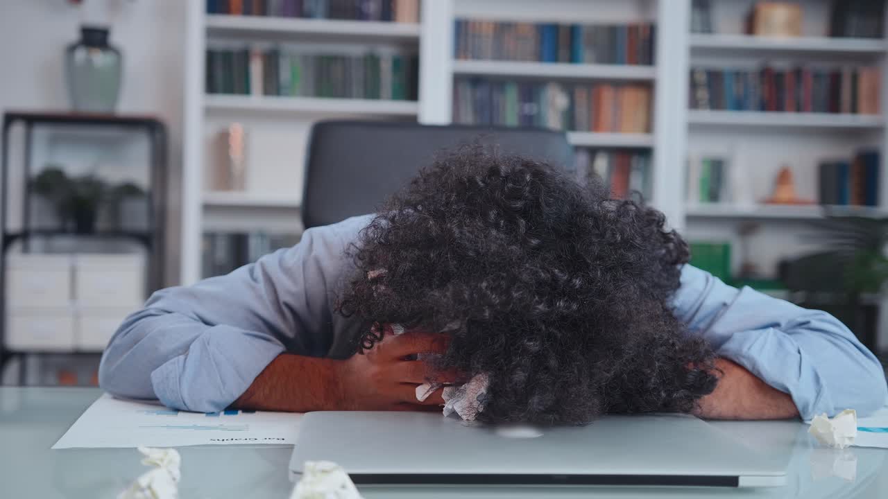 Young arabian business man gets nervous and yawns after finishing paperwork puts