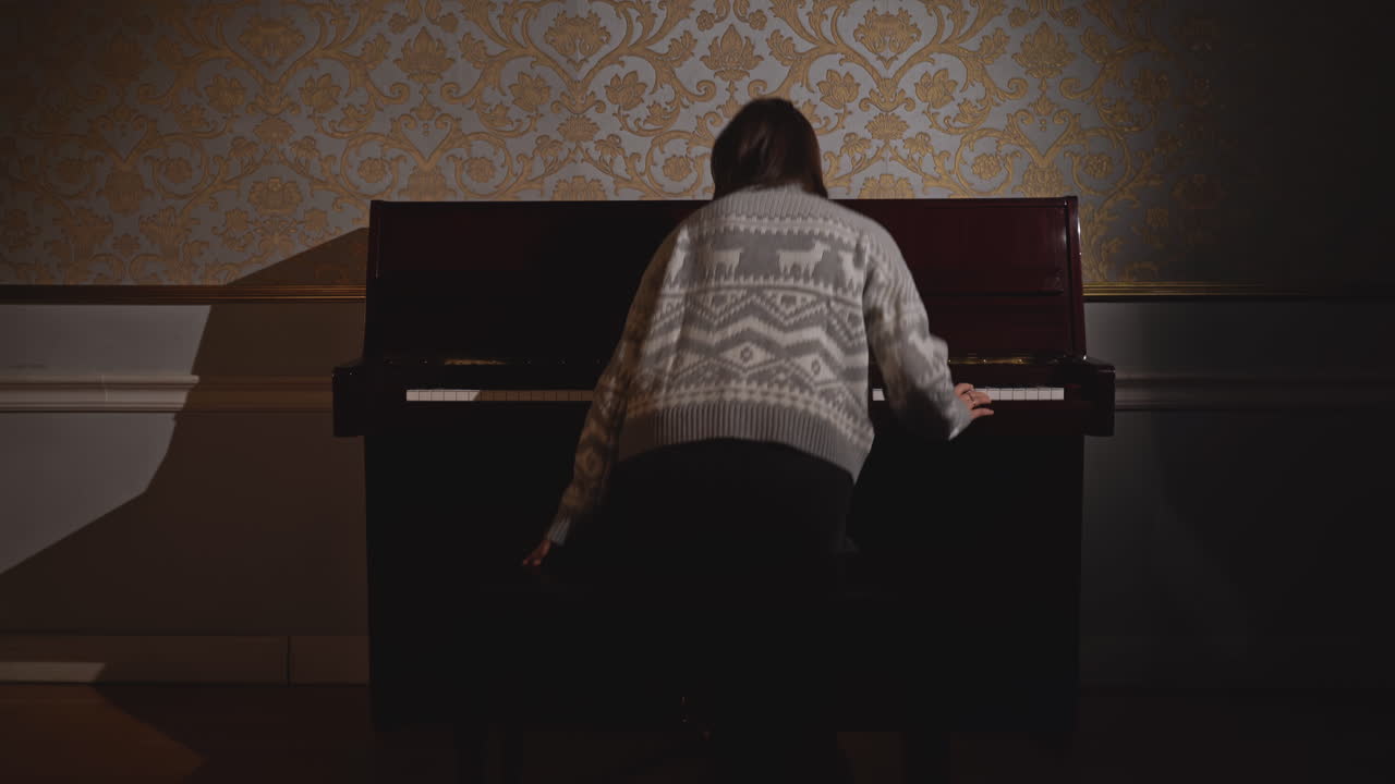 어두운 방에서 피아노를 연주하는 여자