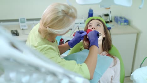 proceso de tratamiento de los dientes con luz de curación dental. dentista trabajando con el paciente