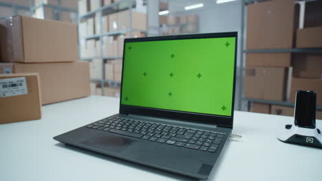 laptop with green screen in a warehouse