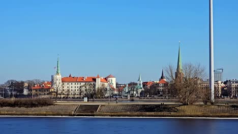 a city riga with a large building with a clock tower and a church