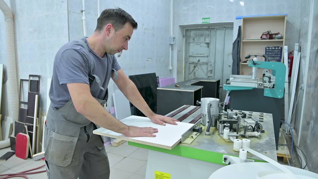 Un uomo lavora su una macchina che processa pezzi di legno in un assemblaggio.