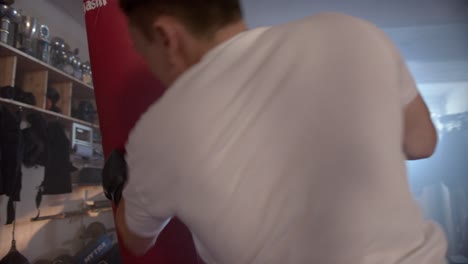 un boxeador se entrena en una sala de entrenamiento con un saco de boxeo rojo