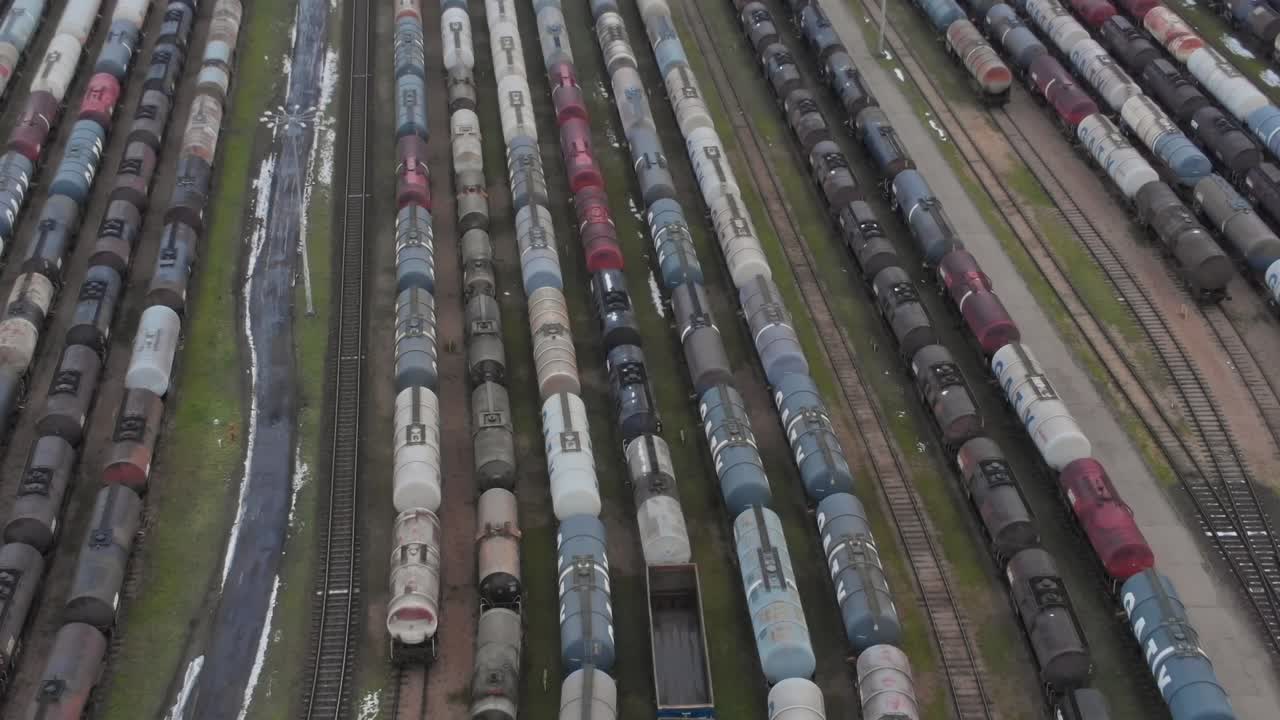 Godstog står opstillet på en rangerplads i en by i overskyet vejr