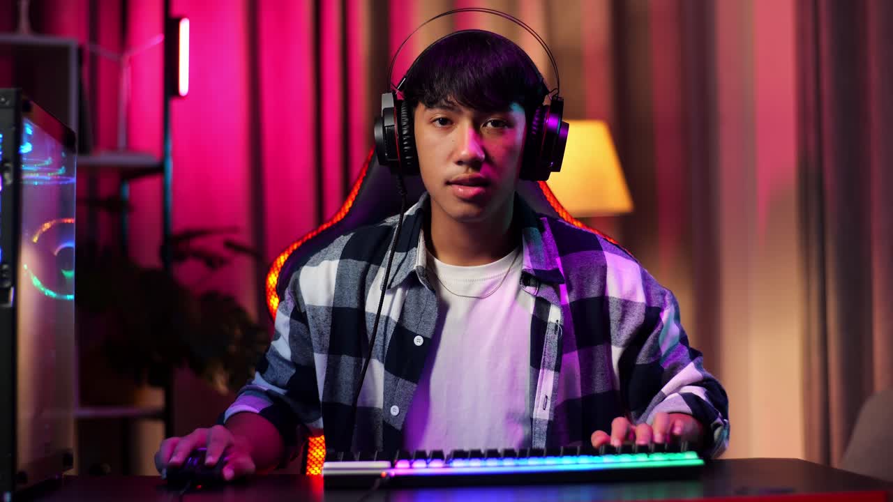 Front View Of Serious Asian Teen Boy Gamer Playing Video Game On Computer