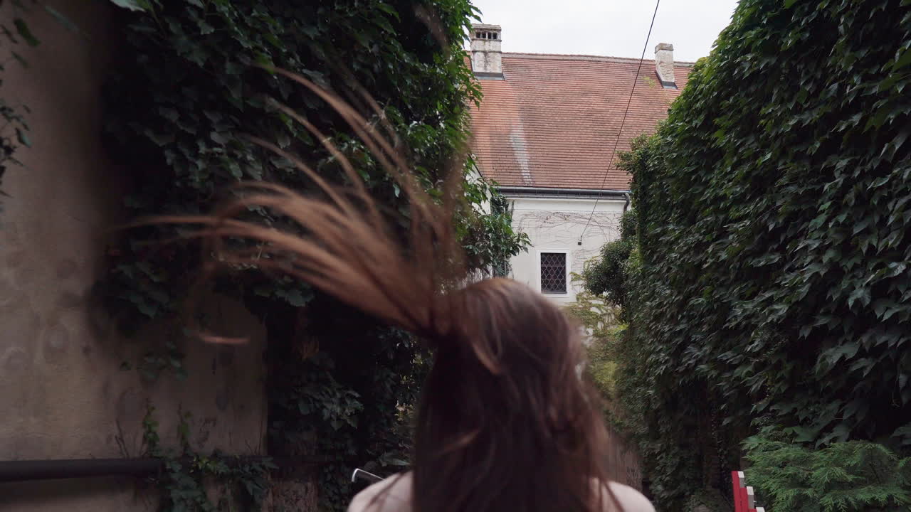 una mujer caminando por un antiguo y encantador callejón europeo.