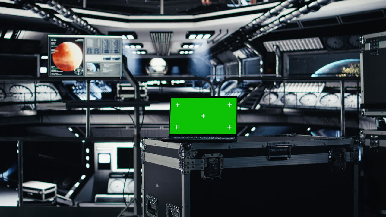 Green screen laptop in spacecraft next to monitor displaying Mars dashboard