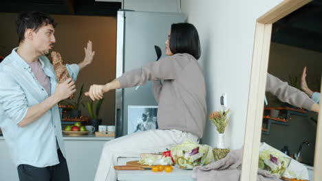 pareja cantando y bailando en la cocina