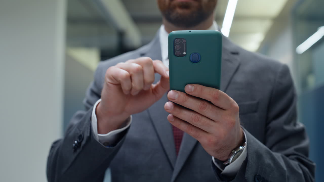 Ceo finger swiping mobile phone walking hall closeup. Businessman going corridor