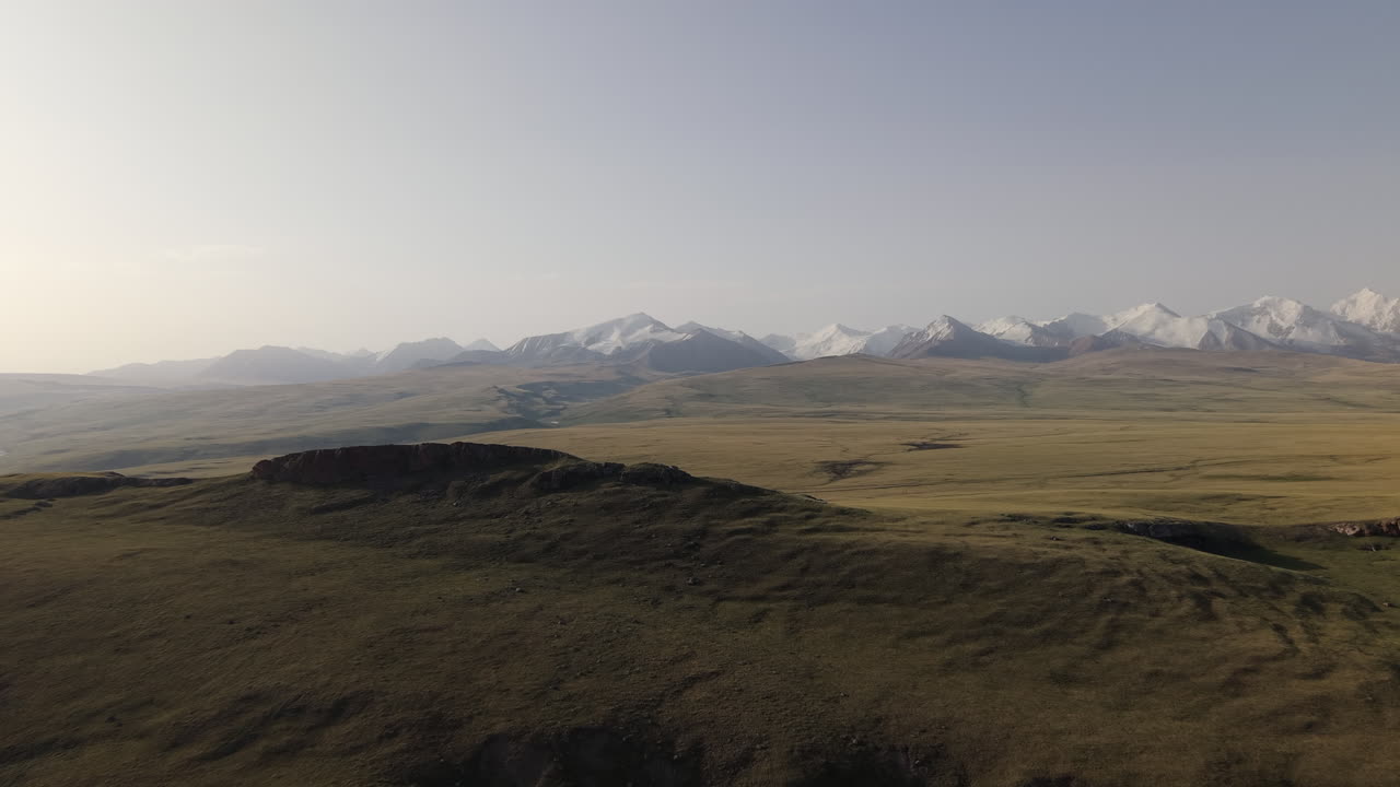 High Altitude Mountain With Snow-capped Peaks On A Foggy Morning In Kyrgyzstan, Central Asia. Aerial Shot
