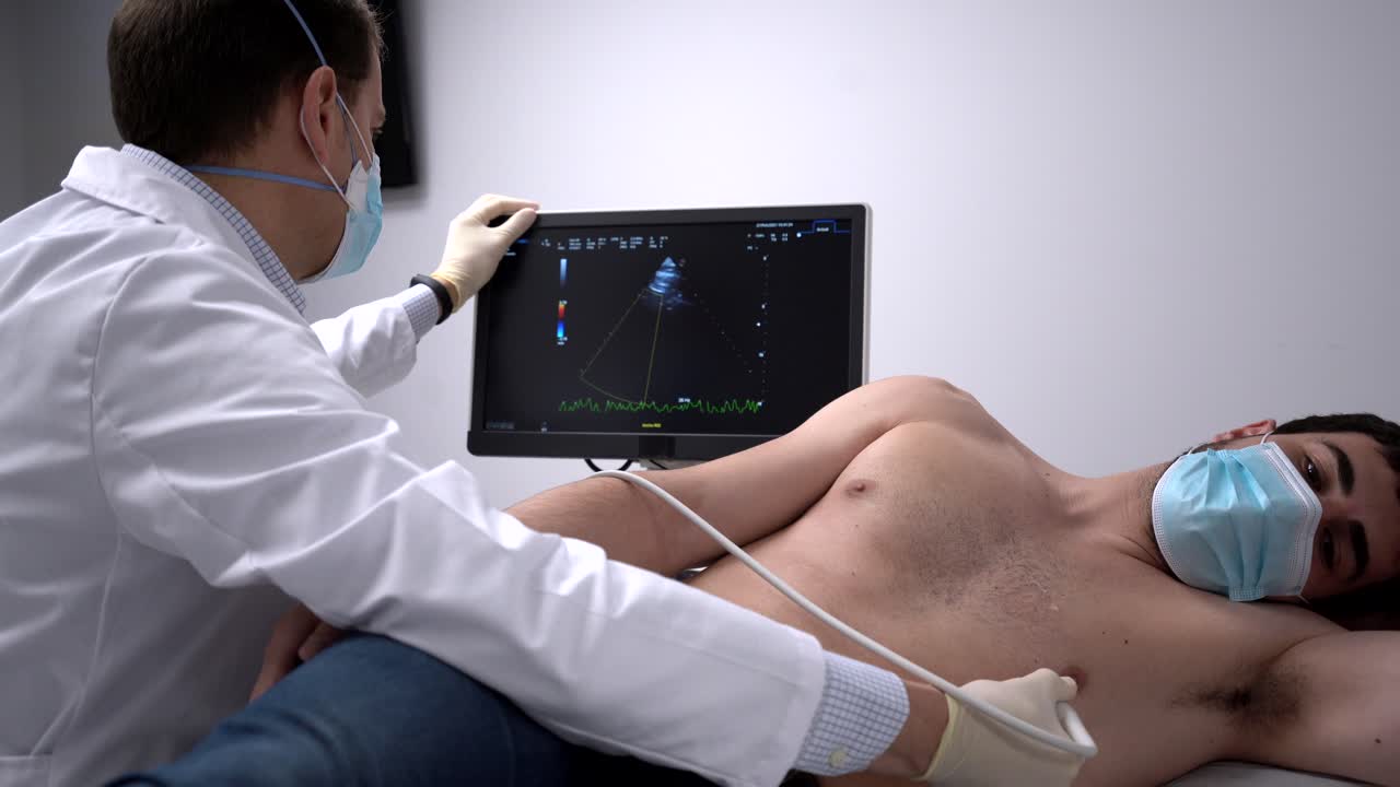 médico que examina el corazón del paciente con un equipo de ultrasonido
