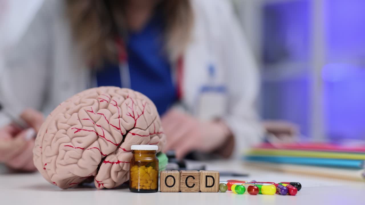 Cubos de madeira formam a abreviação TOC perto de um modelo de cérebro humano.