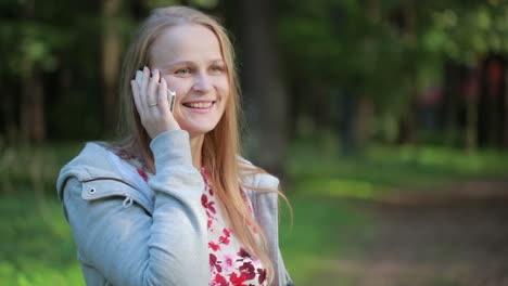 Woman-chatting-on-her-mobile-phone-outdoors