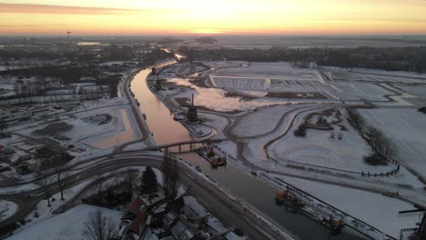 High-above-Strijkmolens-near-Alkmaar-in-wintertime-at-sunrise,-aerial