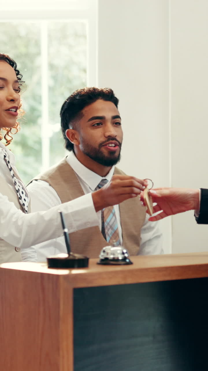 Gentili receptionist d'hotel che consegnano la chiave della stanza