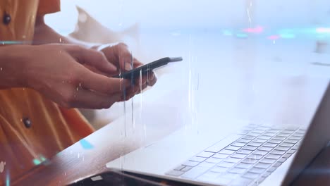 animation of screens of network of connections over mid section of woman using laptop and smartphone